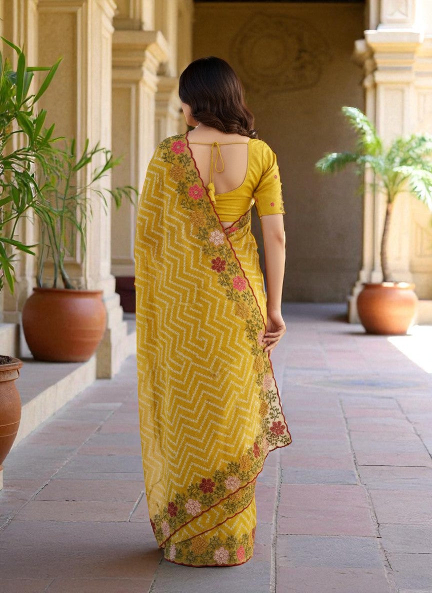 Woman wearing a yellow saree with floral patterns yellow